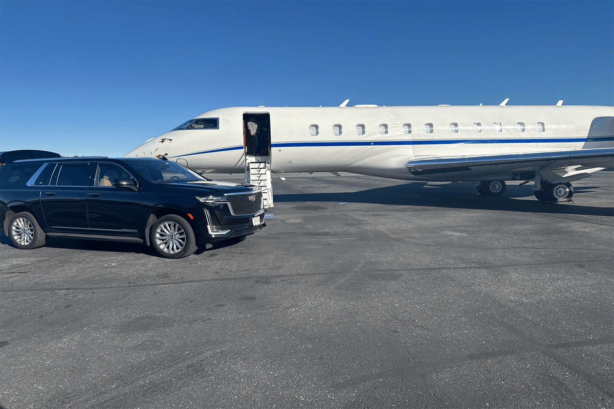 A sleek black Cadillac Escalade parked curbside at Midway Airport, providing spacious and reliable airport transportation service.