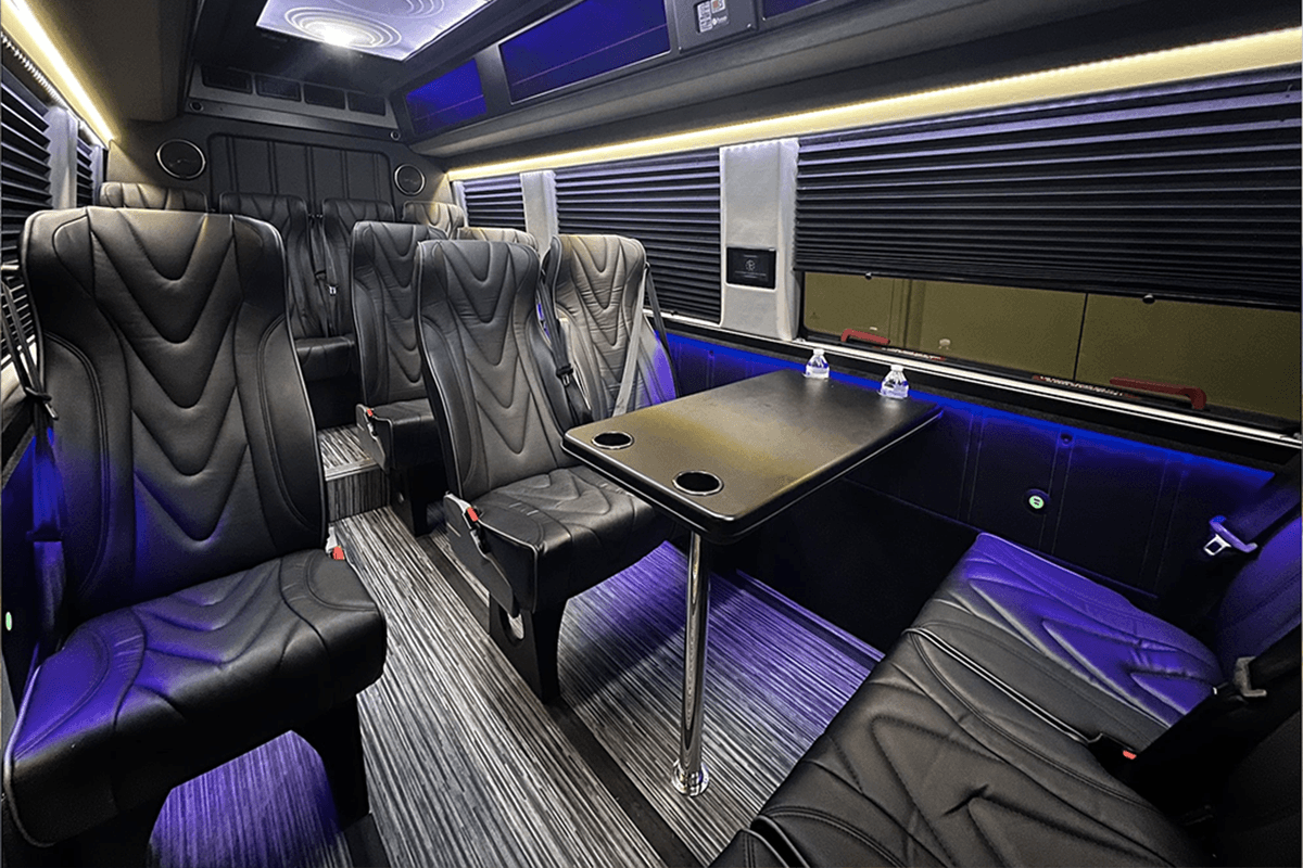 The interior of a luxury Executive Sprinter Van equipped with leather seating, ideal for group corporate transportation and mobile meetings.