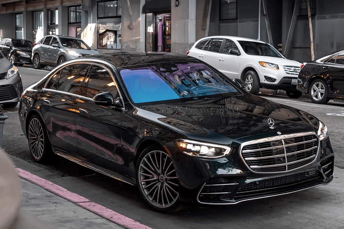 A black Mercedes-Benz S-Class S 580 parked curbside in downtown Chicago, ready for the next stop during an hourly chauffeur service.