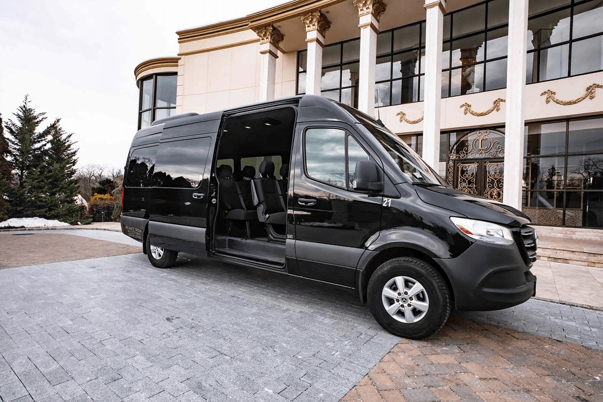 A sleek Executive Sprinter Van waiting at the arrivals curb, offering spacious group Midway Airport limo service in Chicago.