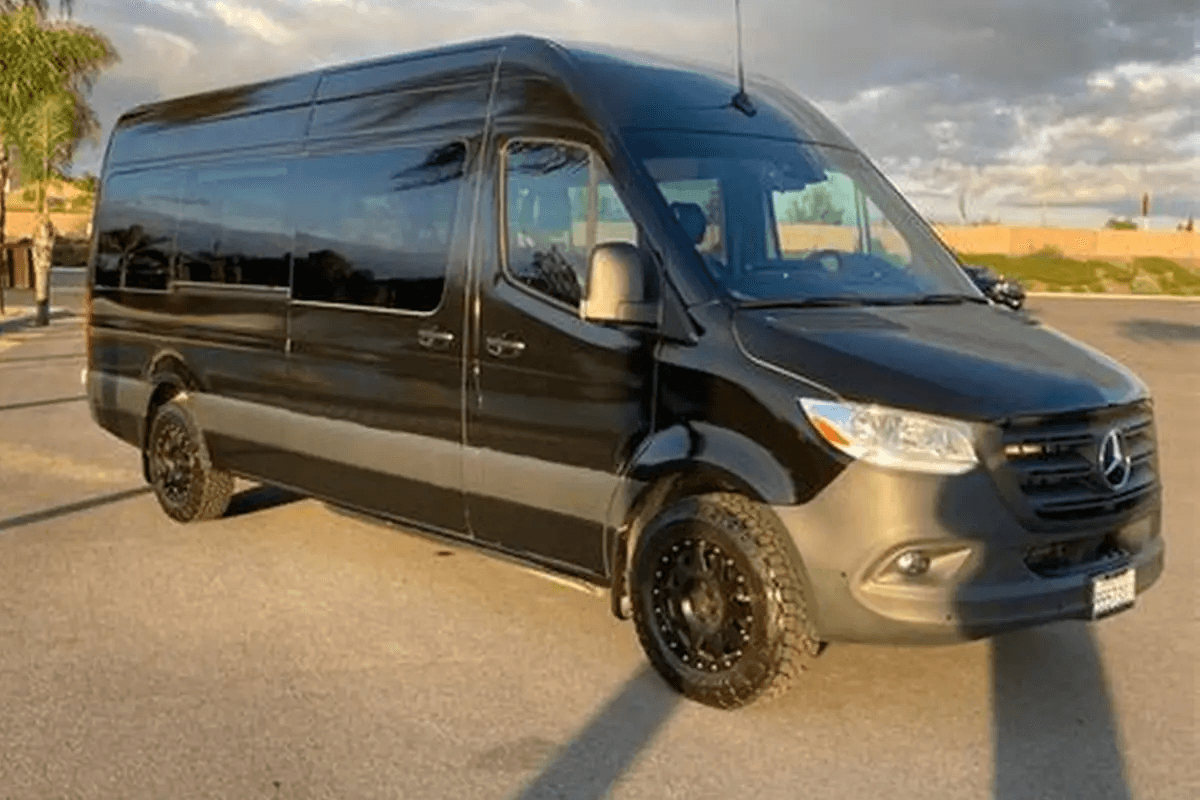 An Executive Sprinter Van parked outside a corporate office, providing seamless point-to-point car service for a business team.