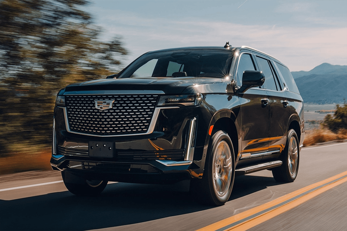 A sleek black Cadillac Escalade driving through downtown Chicago, providing spacious and reliable corporate transportation for a business team.
